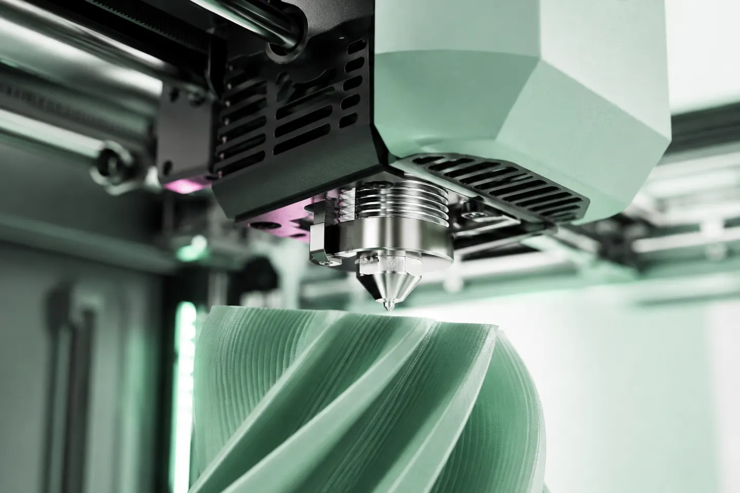 Düse eines 3D-Druckers legt eine Schicht auf ein grünes, gedrehtes Bauteil